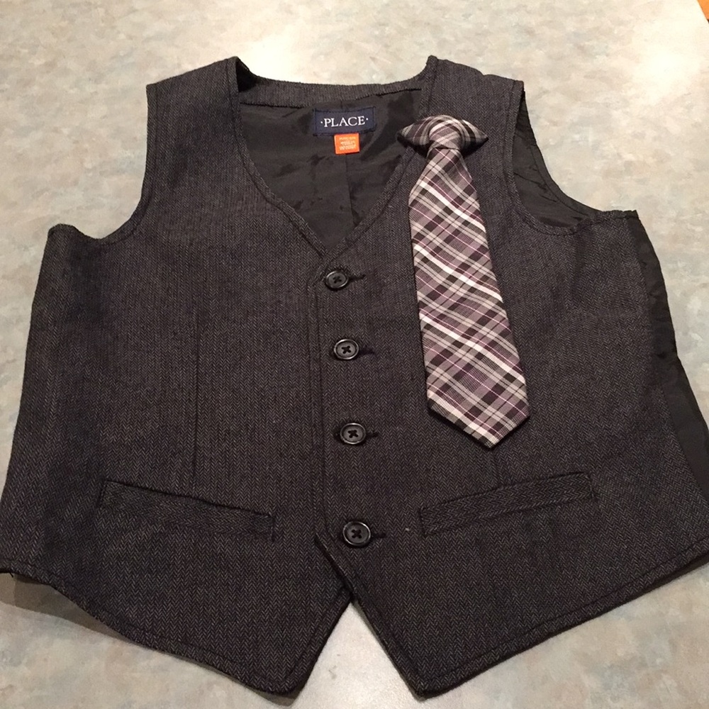 Place boy’s vest and clip on tie